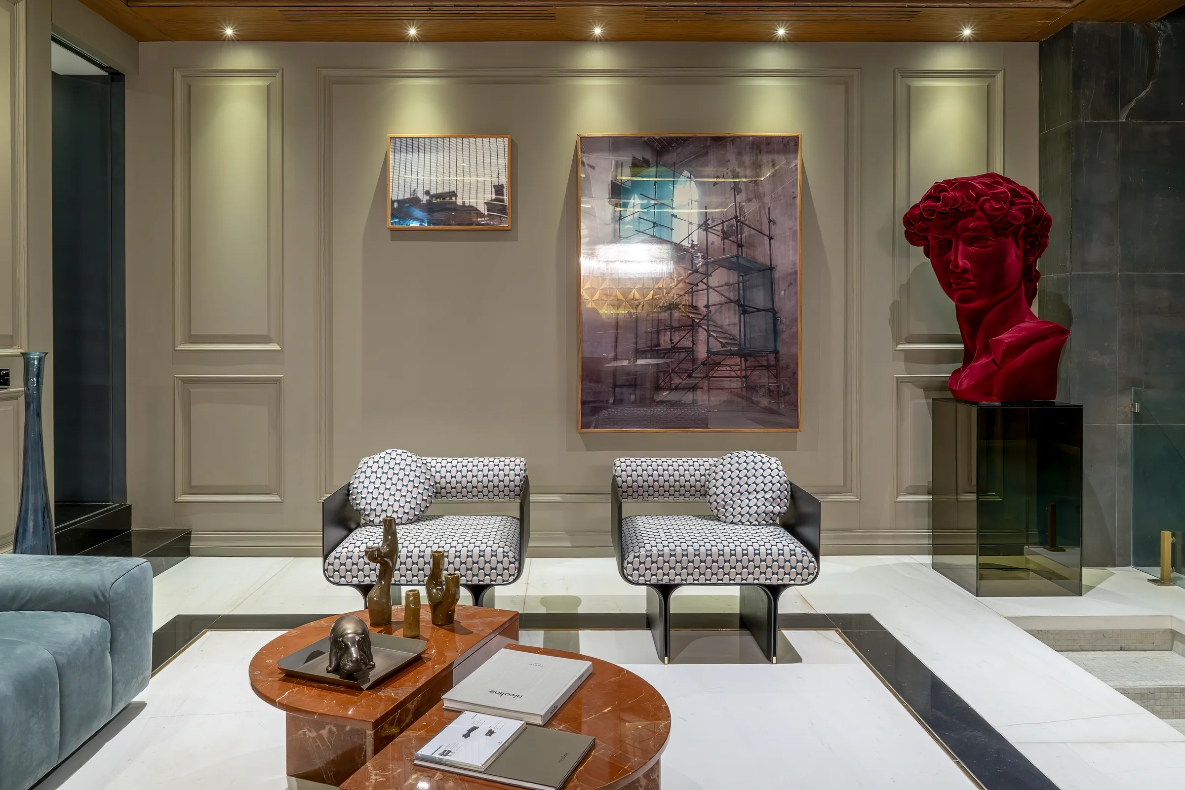 Butacas Stami Lounge de Gallotti&Radice, estampadas, junto a un busto escultórico rojo